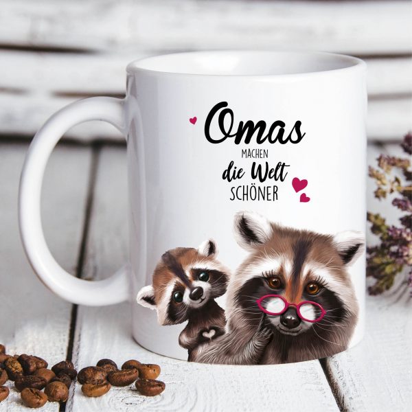 Auf dem Bild ist das Produkt: Bedruckte Tasse Waschbär mit Waschbärkind Omas machen die Welt schöner Geschenk Geburtstag Großmutter zum Preis von €15.90 abgebildet.