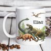 Auf dem Bild ist das Produkt: Kindertasse Tasse Dinosaurier personalisiert Wunschname zum Preis von €18.9 abgebildet.