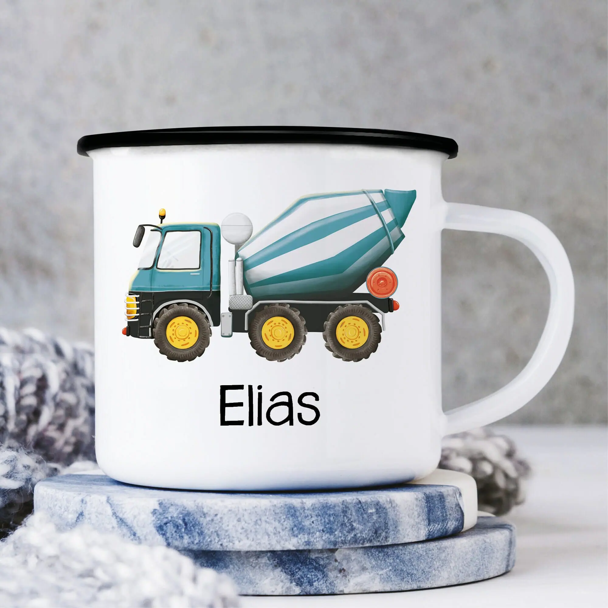 Auf dem Bild ist das Produkt: Campingbecher Emaille mit einem blauen Betonmischer Mischer personalisiert mit Wunschname Junge zum Preis von €18.90 abgebildet.