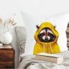 Auf dem Bild ist das Produkt: Herbstlich bedrucktes Kissen mit Aufdruck Waschbär im Regenmantel, Geschenk zum Preis von €18.9 abgebildet.