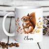 Auf dem Bild ist das Produkt: Keramik Tasse Eichhörnchen und Herbstblätter personalisiert Wunschname zum Preis von €18.9 abgebildet.