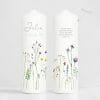 Auf dem Bild ist das Produkt: Weiße Kerze zur Taufe oder Geburt beidseitig bedruckt mit zarten Wildblumen und Wildgräsern zum Preis von €5.9 abgebildet.