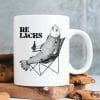 Auf dem Bild ist das Produkt: Tasse bedruckt Lachs mit Bierflasche im Anglerstuhl Relax Relachs Kaffeetasse Kaffeebecher zum Preis von €15.9 abgebildet.