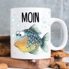 Auf dem Bild ist das Produkt: Bedruckte Keramik Tasse Fisch Moin maritim Geschenk Geburtstag 330 ml weiß zum Preis von €15.90 abgebildet.