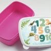 Auf dem Bild ist das Produkt: Brotdose mit Zahlen und Dinosauriern personalisiert mit Wunschnamen Schule Einschulungsgeschenk zum Preis von €16.90 abgebildet.