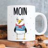 Auf dem Bild ist das Produkt: Keramiktasse Möwe mit Pullover Moin maritim Geschenkidee Geburtstag Kaffeetasse 330 ml zum Preis von €15.90 abgebildet.