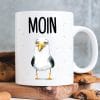 Auf dem Bild ist das Produkt: Keramiktasse Möwe Moin maritim Geschenkidee Geburtstag Kaffeetasse 330 ml zum Preis von €15.90 abgebildet.