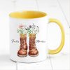 Auf dem Bild ist das Produkt: personalisierte Tasse mit Wanderstiefeln und Wildblumen Becher Geburtstagsgeschenk für einen Naturliebhaber mit Namen zum Preis von €17.90 abgebildet.