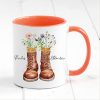 Auf dem Bild ist das Produkt: personalisierte Tasse mit Wanderstiefeln und Wildblumen Becher Geburtstagsgeschenk für einen Naturliebhaber mit Namen zum Preis von €17.90 abgebildet.