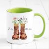 Auf dem Bild ist das Produkt: personalisierte Tasse mit Wanderstiefeln und Wildblumen Becher Geburtstagsgeschenk für einen Naturliebhaber mit Namen zum Preis von €17.90 abgebildet.