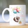 Auf dem Bild ist das Produkt: Tasse aus Keramik mit niedlichem Waschbär Motiv mit Korb und Luftballons, personalisiert mit Wunschnamen zum Preis von €16.9 abgebildet.