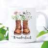 Auf dem Bild ist das Produkt: Tasse bedruckt mit Wanderstiefeln mit Wildblumen Gräsern und Wanderlust Kaffeetasse Geschenk zum Preis von €18.9 abgebildet.