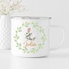 Auf dem Bild ist das Produkt: Tasse Emaille Campingbecher Hase im Blätterkranz mit Blumen und Wunschnamen zum Preis von €18.9 abgebildet.