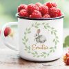 Auf dem Bild ist das Produkt: Tasse Emaille Campingbecher Hase im Blätterkranz mit Blumen und Wunschnamen zum Preis von €18.9 abgebildet.