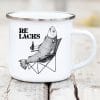 Auf dem Bild ist das Produkt: Re Lachs Campingbecher Emaille bedruckt mit einem Lachs mit Bierflasche im Anglerstuhl Relax Relachs zum Preis von €18.9 abgebildet.
